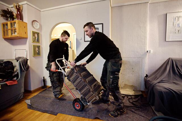 Montørene David og Martin Ingolfsen (til v.) setter inn en ny ovn hos en kunde i Solheimsviken. 