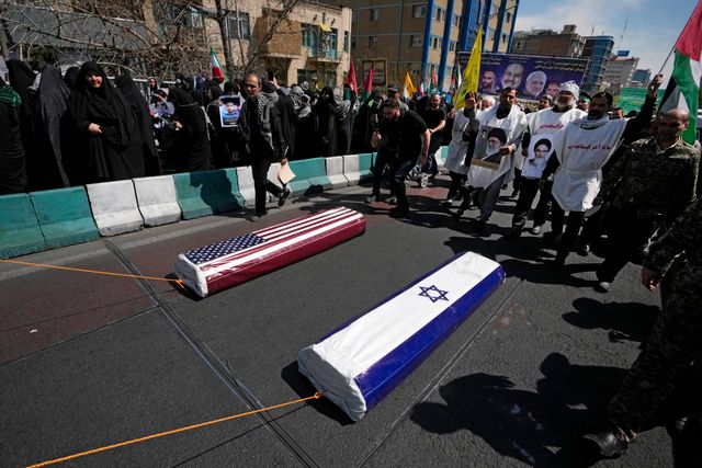 Två kistor symboliskt draperade med USA:s och Israels flaggor dras på en gata under Qudsdagen i Irans huvudstad Teheran.