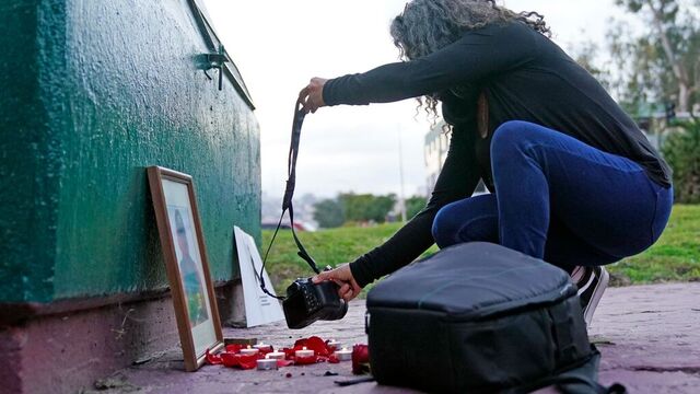 En kollega legger ned et kamera ved en minnemarkering for den drepte fotojournalisten Margarito Martinez. Foto: Gregory Bull / AP / NTB