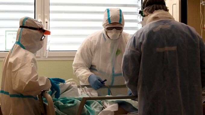 Leger med beskyttelsesutstyr behandler en koronasmittet pasient på et sykehus i Varese i Italia.