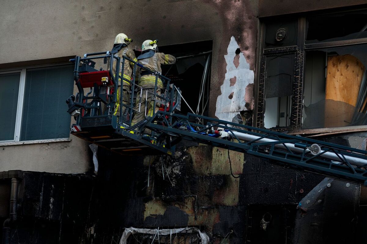 Räddningsarbetare söker igenom byggnaden efter branden. 