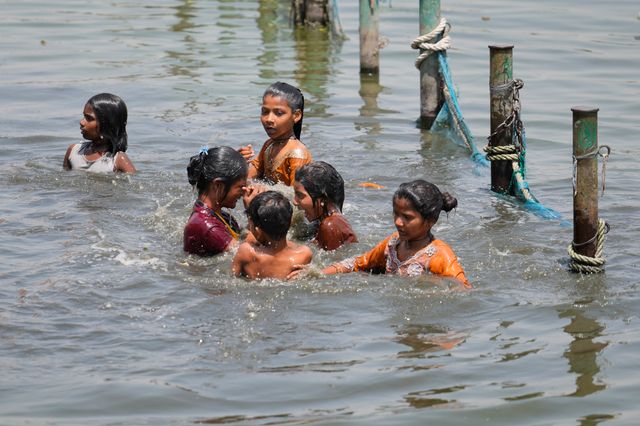 Badande barn i Gomatifloden i norra Indien under landets värmebölja i april.
