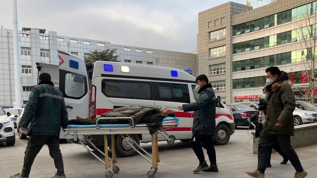 En pasient trilles inn på et sykehus i byen Zhuozhou i den kinesiske Hebei-provinsen onsdag. Verdens helseorganisasjon (WHO) er svært bekymret over økningene av koronasmitte i Kina. Foto: AP / NTB
