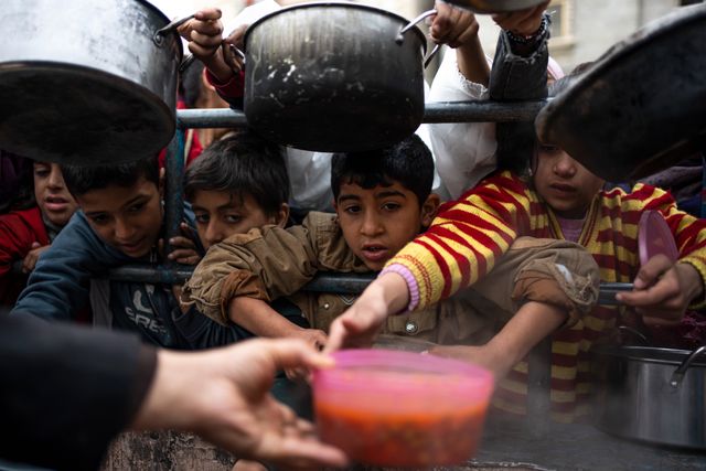 Palestinska barn köar för ett gratis mål mat i Rafah den 16 februari.