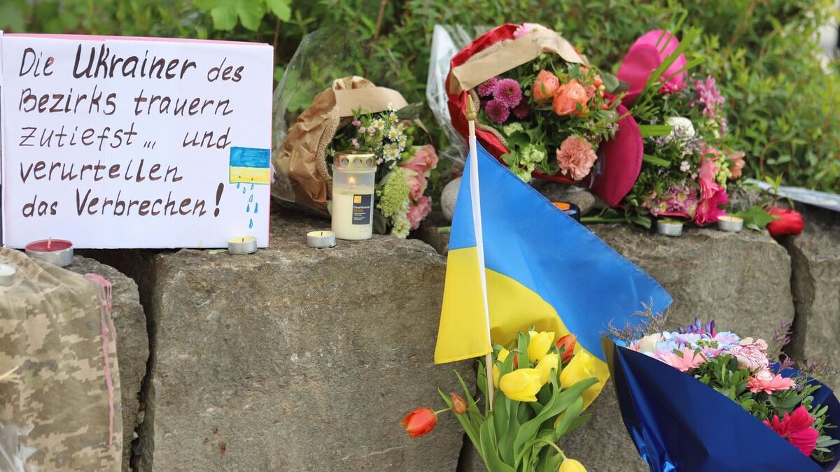 Blomster og et ukrainsk flagg er lagt ned ved kjøpesenteret i Murnau.