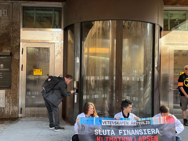 Demonstranter sitter utanför finansdepartementet.