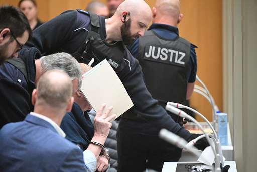 En tiltalt mann ledes inn i lokalet i Stuttgart.