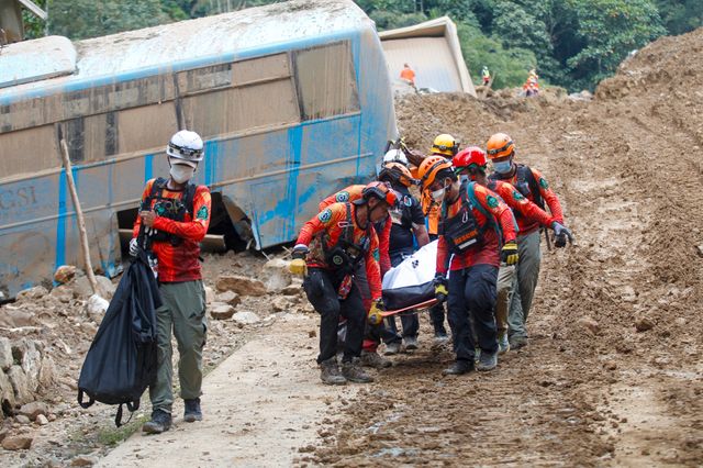 Räddningsarbetare i det skreddrabbade samhället Masara i torsdags. Arkivbild.