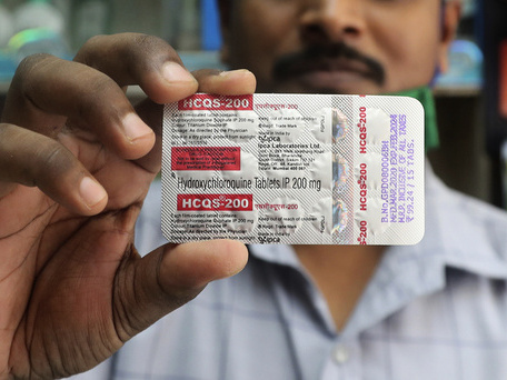 En apoteker i Mumbai i India holder opp en pakke med hydroksylklorokin, en av medisinene som prøves ut i behandlingen av covid-19. Nye forskningsresultater tyder på at medisinen ikke er effektiv mot sykdommen, og også forårsaker omfattende bivirkninger.