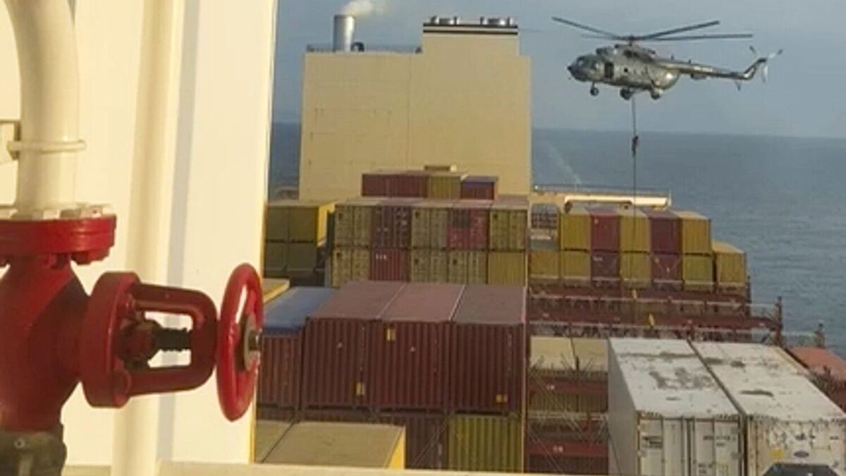 Et bilde fra en video som viser kommandosoldater som heises ned fra et helikopter til et konteinerskip i Omanbukta. Foto: AP / NTB 