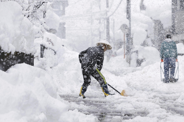 En man skottar snö staden Nagaoka i norra Japan.
