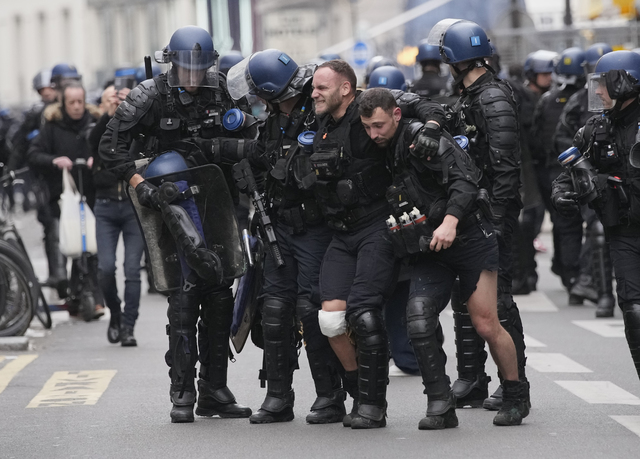 En av de skadade poliserna i Paris bärs bort av sina kollegor.