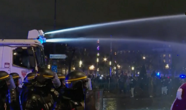 Kravallpolis med vattenkanoner i Paris på lördagskvällen. 