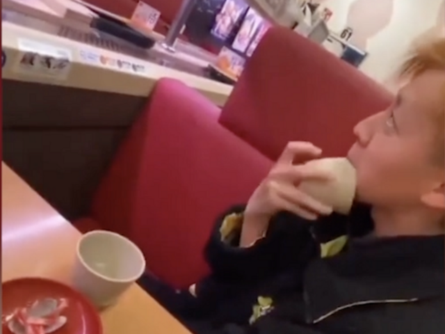 En ungdom som slickar en skål vid en sushirestaurang. Han har sedan bett om ursäkt till ägaren.