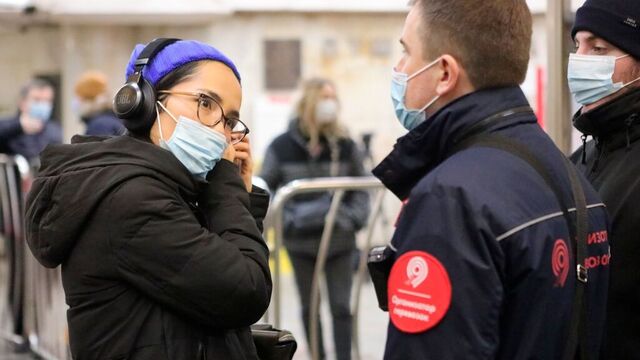 En kontrollør sjekker at folk bruker munnbind på offentlig transport i Moskva. Foto: Sophia Sandurskaya / Moscow News Agency photo via AP / NTB