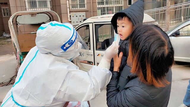 Et barn blir testet for koronaviruset i Huaxian i Henan-provinsen sentralt i Kina. Foto: Chinatopix via AP / NTB