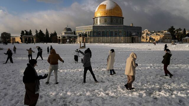 Palestinere leker i snøen ved Klippedomen i Jerusalem. Foto: Mahmoud Illean / AP / NTB