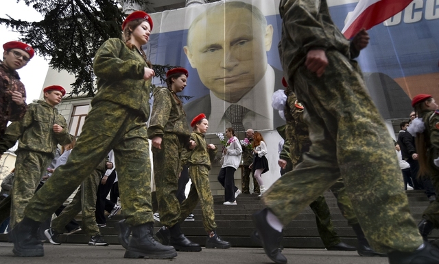 Militärklädda ungdomar i Jalta på Krimhalvön firar årsdagen av den ryska annekteringen.