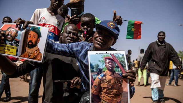 En mann holder et portrett av juntaleder Paul Henri Sandaogo Damiba. Foto Sophie Garcia / AP / NTB