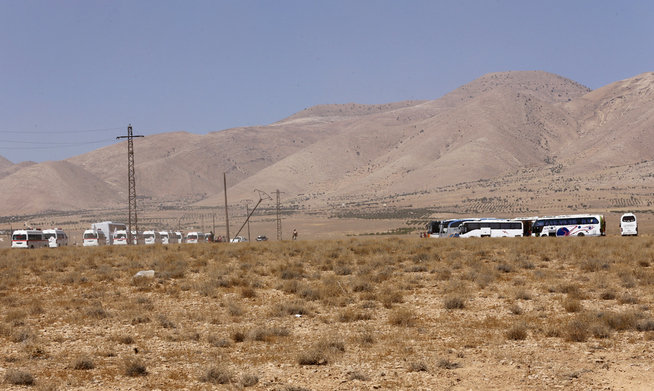<p>KONVOI: De elleve ambulansene og 17 bussene som skulle frakte over 600 IS-krigere og deres familiemedlemmer hundrevis av kilometer gjennom regimekontrollerte områder til Deir al-Zor er her fotografert i Qalamoun-regionen vest i Syria før ferden startet i begynnelsen av forrige uke.</p>