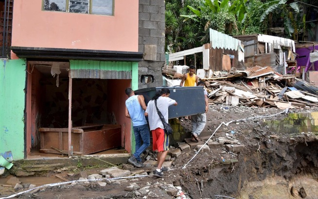 <p>STORE ØDELEGGELSER: Menn bærer et kjøleskap utenfor San Jose på Costa Rica. Boligområdet fikk store skader i et jordskred som følge av uværet. </p>