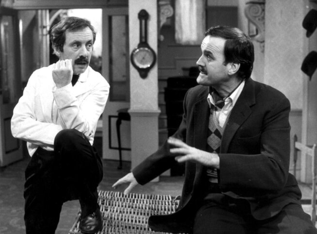 <p>KOMIKER-DUO: Andrew Sachs (t.v.) som kelneren Manuel i TV-serien «Hotell i særklasse». Her sammen med serieskaper John Cleese i rollen som Basil Fawlty.</p>
