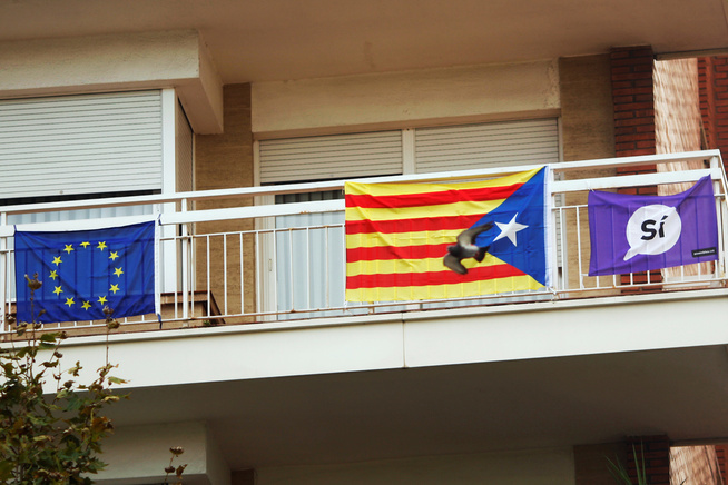 <p>¿INCOMPATIBLE? Noen har hengt separatistflagget og et banner med "ja" til uavhengighet, side om side med EU-flagget. Men EU sier katalanerne ikke kan gå ut fra at de blir værende EU-medlemmer, dersom de forlater Spania. FOTO: REUTERS</p>