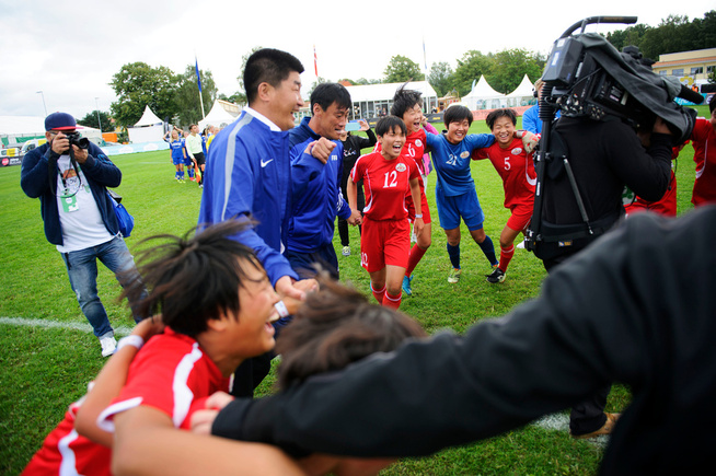 <p>SEIERSDANS: Nordkoreanerene jubler etter kampslutt. I blått er lagets trenere Jang Kyong Il og Kim Sang Hyop, lagets kaptein, Hong Song Ok (12), Choe Song Gyong (16), reservekeeper Won Jin Sim (21) og Jo Il Gyong (5). Spillernes nummer i parentes.</p>