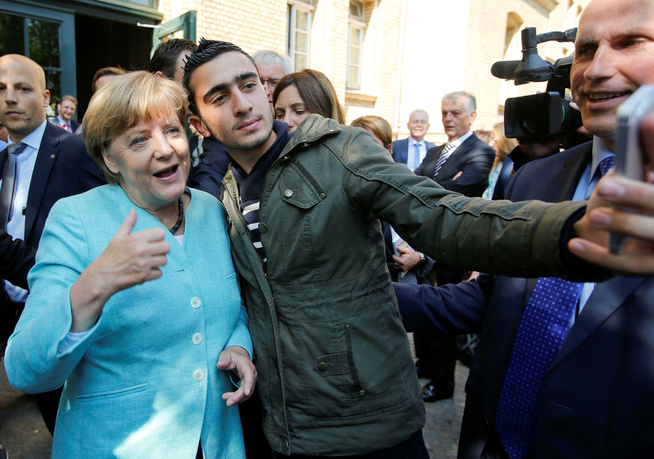 <p>MERKEL MED ÅPNE ARMER: Den syriske flyktningen Anas Modaman får en selfie med Angela Merkel i Berlin. Ikke alle tyske politikere er like åpen for å ta imot så mange flyktninger, som Merkel ønsker. FOTO: REUTERS</p>