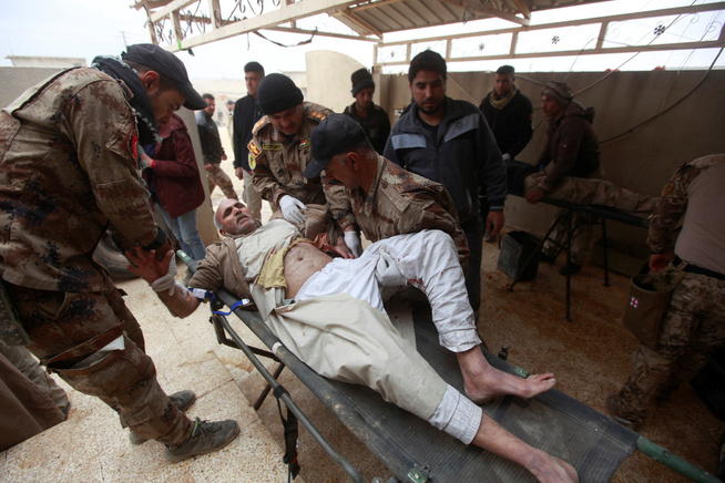 <p>SÅRET: Irakiske sikkerhetsstyrker hjelper en mann som har blitt såret i kampene i Mosul i Irak. FOTO: ALAA AL-MARJANI/REUTERS</p>