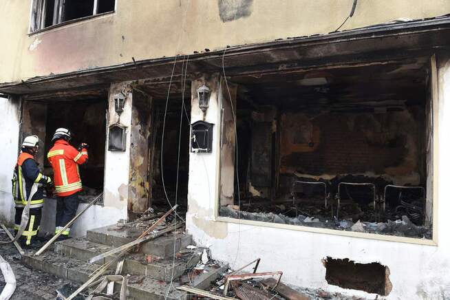 <p>ASYLMOTTAK I BRANN: Brannmenn jobber med å slukke en brann på asylmottaket i Goessweinstein i Bavaria i august. Årsaken til brannen er ikke kjent. FOTO: AFP</p>